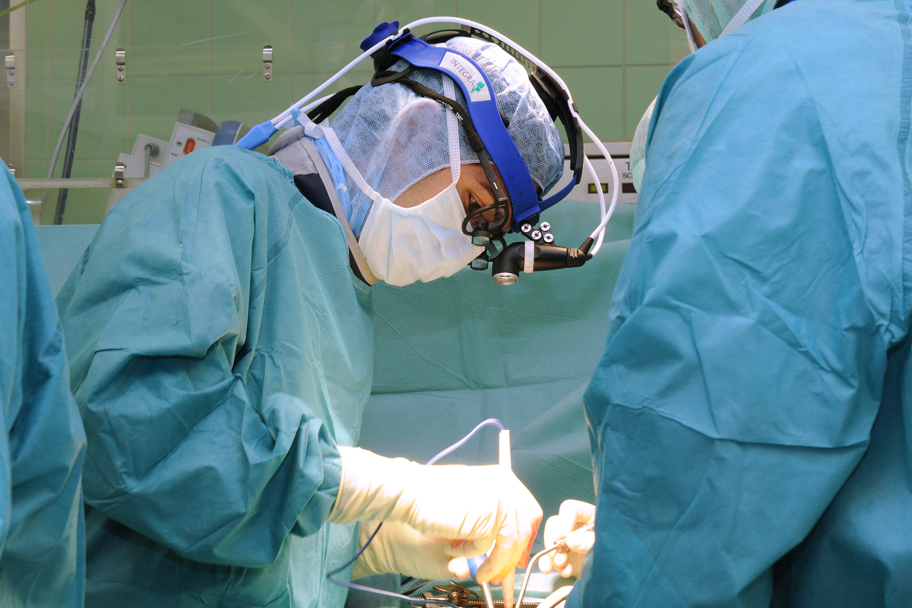 A surgeon operates on a patient's spine in the operating room