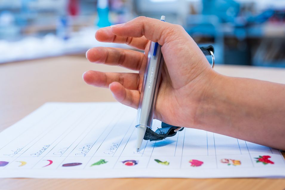 Close-up of a right hand holding a pencil and drawing.