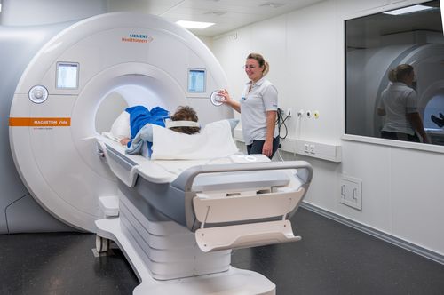 Eine Radiologiefachperson bereitet eine Patientin für die Untersuchung im 3-Tesla-Magnetresonanzgerät (MRI) vor.