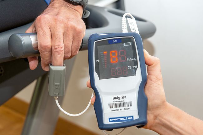 Eine Physiotherapeutin misst die Sauerstoffkonzentration im peripheren Blut (Pulsoxymetrie). Sauerstoffmessung am Finger.