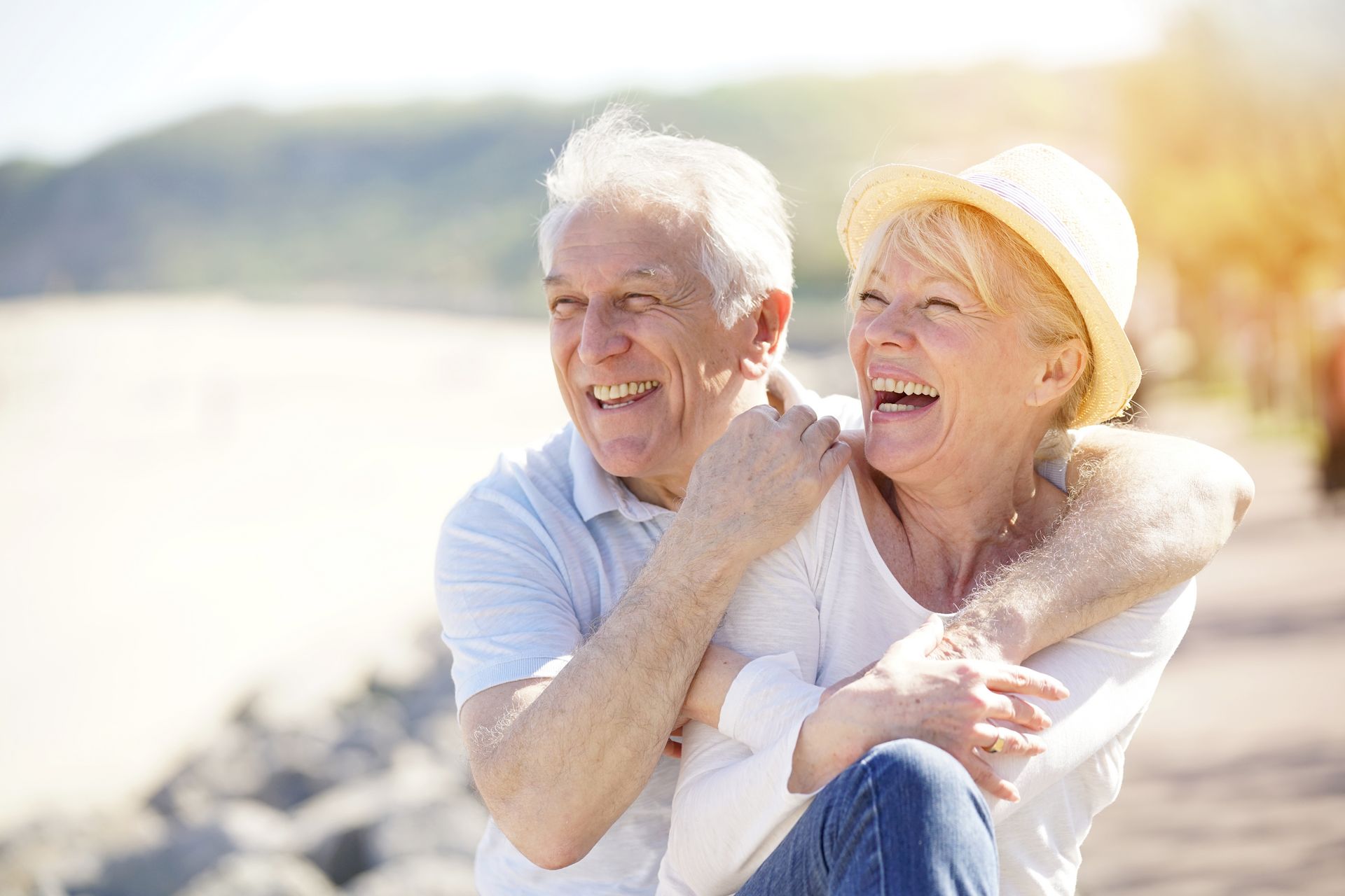 Ein älteres Senioren-Paar lacht gemeinsam am Stand. 