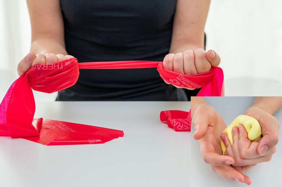 A patient holds a red theraband in both hands and pulls it tight.