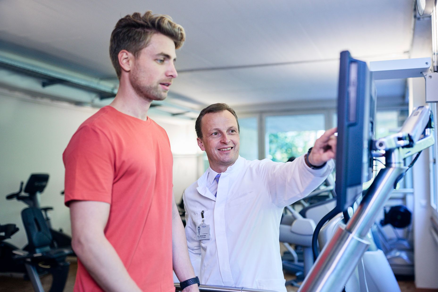Patient in sports medicine is cared for on the treadmill by the sports doctor.