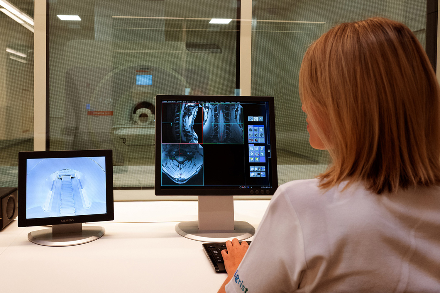 Eine Forscherin betrachtet ein MRI eines Patienten am Computer.