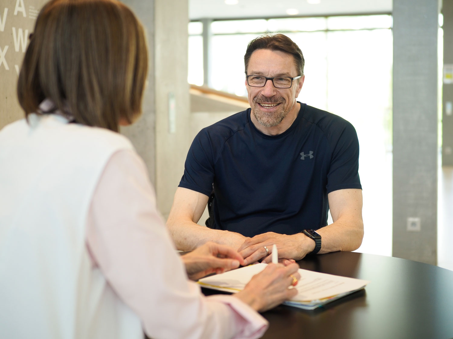 Patient Lars Berger im Gespräch mit Study Nurse Andrea Prusse Ein Patient mit Querschnittlähmung unterhält sich mit einer Study Nurse.