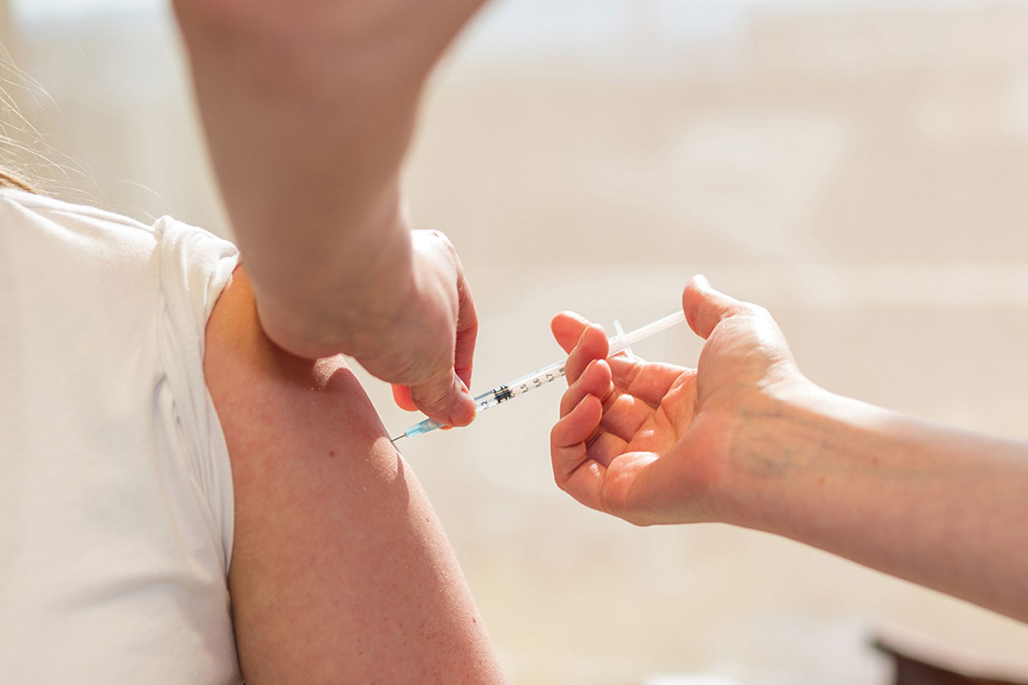 Einer Mitarbeiterin wird eine Covid-Impfung verabreicht.