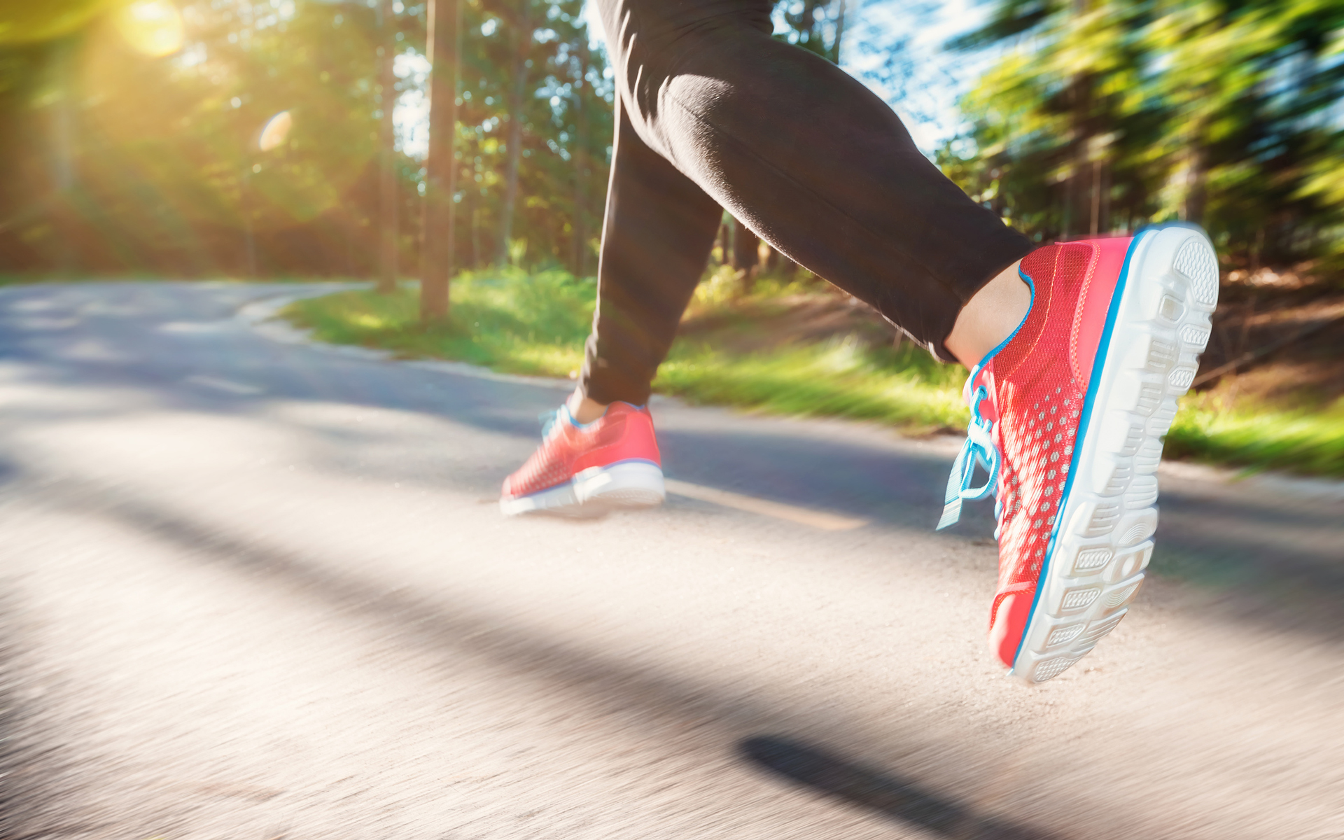 Eine Joggerin springt über den Asphalt